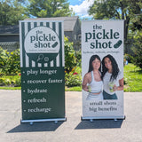 Two promotional banners for 'the pickle shot' in an outdoor setting. These are made of Retractable Banner Stands.